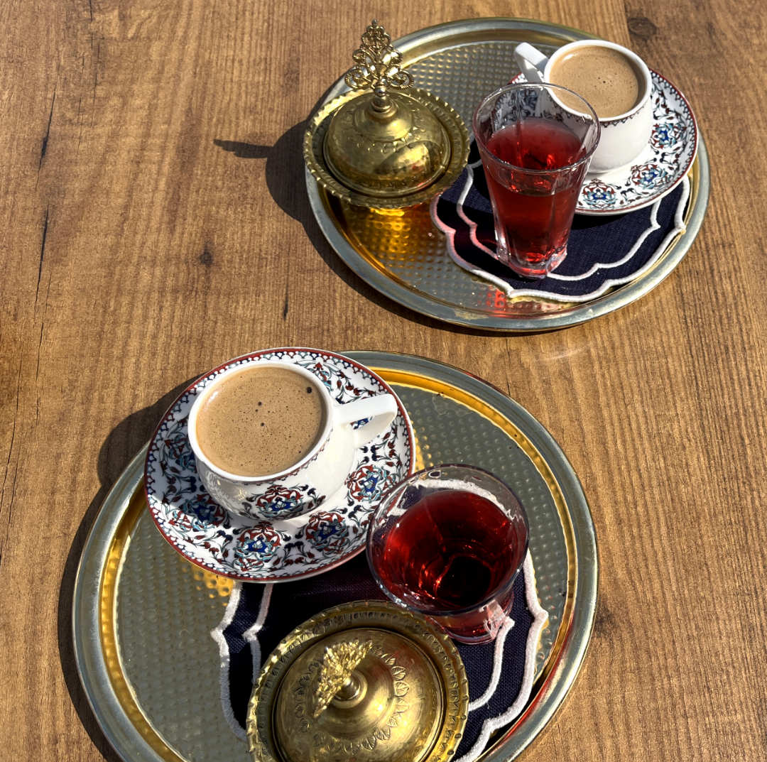 Zwei Tabletts mit Kaffee und rotem Tee auf einem Holztisch